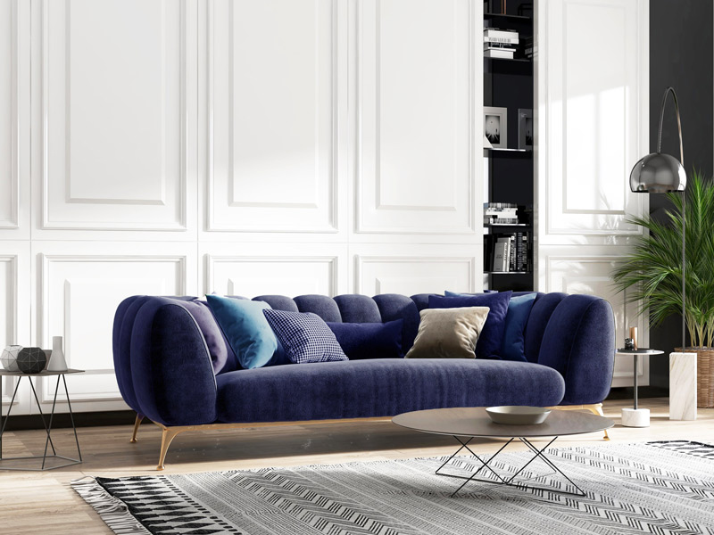 Modern living room with a navy blue velvet sofa and white paneled walls